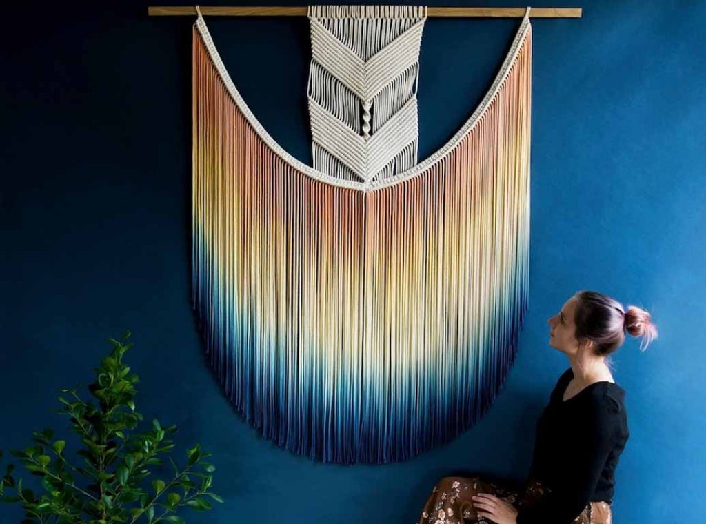 A giant necklace- like macrame on an indigo blue wall I ZenQ Designs