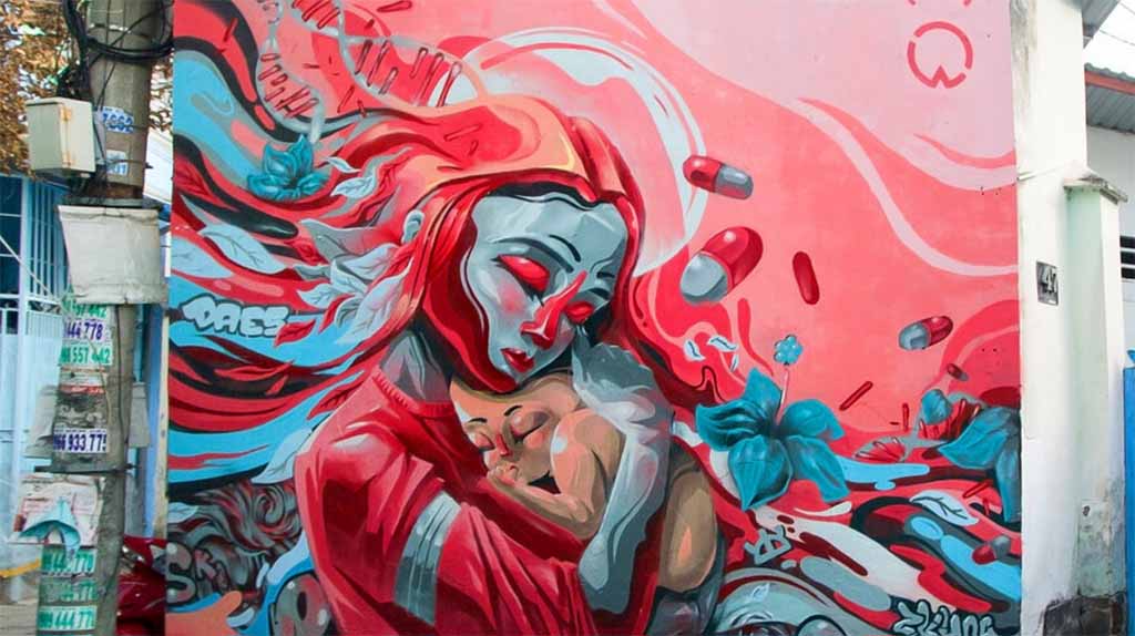 A street red and blue mural of a mother holding her baby I ZenQ Designs